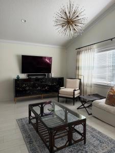 a living room with a couch and a table and a chandelier at Regiane Residence in Wellington