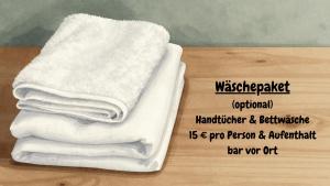 a stack of white towels sitting on a table at Waldsiedlung - Haus 9 in Senftenberg