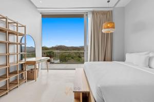 a bedroom with a bed and a desk and a window at Beachfront Modern Sanctuary - Bolongo in Higuera Blanca +57 photos