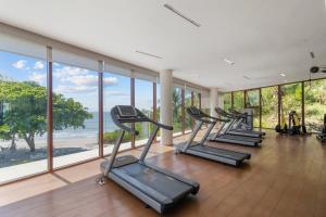 a row of treadmills in a gym with windows at Beachfront Modern Sanctuary - Bolongo in Higuera Blanca