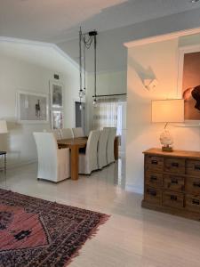 a dining room with a table and white chairs at Regiane Residence in Wellington