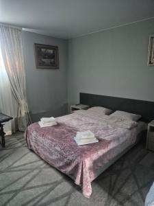 a bedroom with a bed with two towels on it at Oasis in Edineţ +16 photos