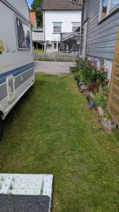 a van parked in a yard next to a house at Mikael's Bed & Spa - Camping Suite in Sandefjord +4 photos