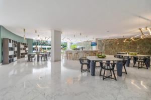 a room with tables and chairs and a kitchen at Beachfront Modern Sanctuary - Bolongo in Higuera Blanca