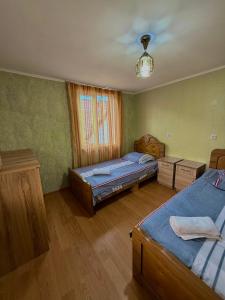 a bedroom with two twin beds and a window at Guesthouse Roza in Tsvirmi