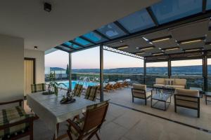 a living room with a table and chairs and a pool at Villa Sunset Mostar in Mostar