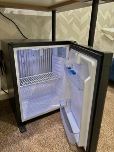 an empty refrigerator with its door open on the floor at Hotel Alto in Karakol