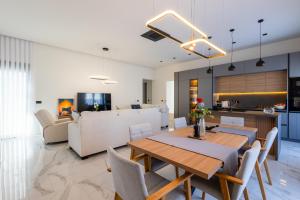 a dining room and living room with a table and chairs at Villa Sunset Mostar in Mostar