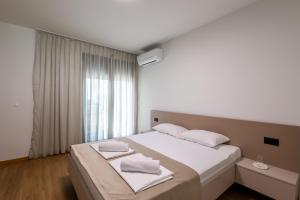 a bedroom with a large white bed with white towels on it at Villa Sunset Mostar in Mostar +26 photos