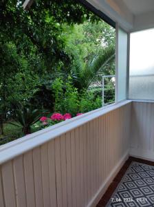 a balcony with a large window and pink flowers at Ksandra in Topla