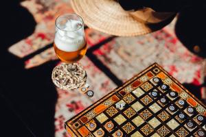 a glass of beer sitting on a table with a hat at Casa Boho - Turismo Rural in Alvados
