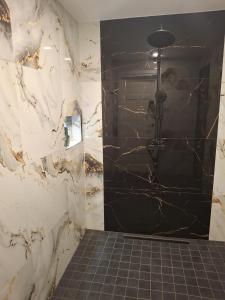 a bathroom with a black and white marble shower at Riverside Sauna House in Savala +8 photos