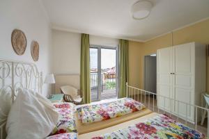 a bedroom with two beds and a balcony at Gästehaus Elfriede in Mörbisch am See