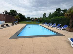 a swimming pool with lounge chairs next to at Mekxy in Herkingen