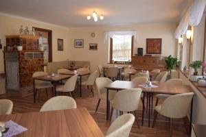 a restaurant with tables and chairs in a room at Pension Lachmann in Pfaffendorf