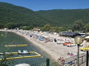 a group of people on a beach with boats in the water at Apartman IDEA in Rabac