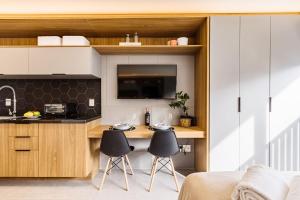 a kitchen with a table and two chairs in a room at GO 24 by My Way in Porto Alegre