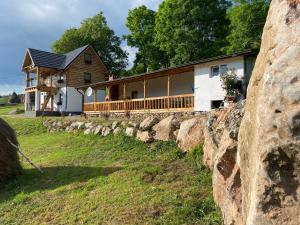 a house on a hill with a stone wall at Căsuța Anei in Rîmeţi-Valea Inzelului