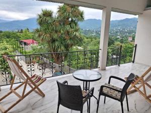 a balcony with a table and chairs and a view at Nutsa House in Ts'ikhisdziri