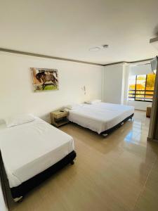 a bedroom with two beds and a window at hotel boutique in Pereira