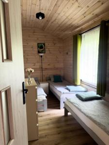 a room with two beds in a wooden cabin at Domki u Czopera in Zełwągi +46 photos