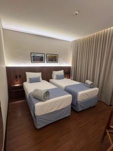 two beds in a hotel room with two at Class Hotel Americana in Americana