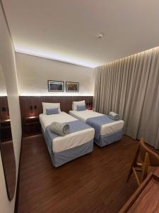 two beds in a hotel room with at Class Hotel Americana in Americana