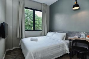 - une chambre avec un lit, un bureau et une fenêtre dans l'établissement Chariton Hotel Alma, à Bukit Mertajam