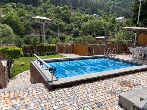 a large swimming pool in a yard with a fence at Two Dilijan big pool in Dilijan