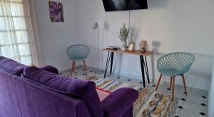 a living room with a purple couch and two chairs at Casas Hoya Limpia- Sólo Adultos in Santa Cruz de la Palma