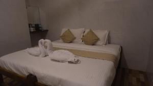 two beds with stuffed animals on top of them at Amani Beach Stay in Māvalli