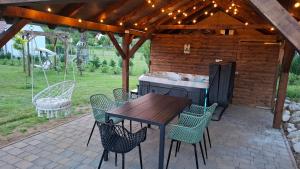 a patio with a table and chairs under a pergola at Mirtusz Apartmanház in Balatongyörök