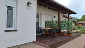 a patio with chairs and a table on a house at Mirtusz Apartmanház in Balatongyörök