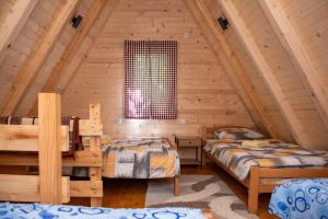 a bedroom with two beds in a log cabin at WildBeauty Grebaje in Vusanje