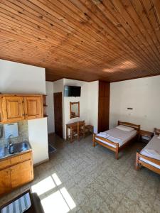 a room with two beds and a kitchen at Avgoustina Venus Studios in Benitses