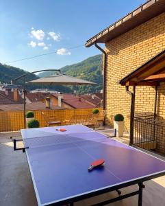 a ping pong table sitting on top of a patio at Cozy Apartment with Balcony in Ivanjica