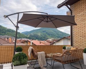 a patio with a table and chairs and an umbrella at Cozy Apartment with Balcony in Ivanjica