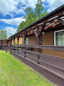 a wooden fence in front of a house at Domki u Czopera in Zełwągi