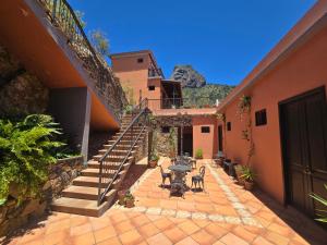 a courtyard of a house with a table and stairs at Tamahuche Hotel Rural in Vallehermoso