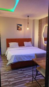 a bedroom with a large bed and a table at The Royam Hotel and Apartments in Ibadan