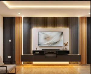 a living room with a television on a wall at The Royam Hotel and Apartments in Ibadan