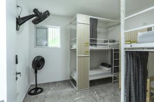 a room with bunk beds and a fan in it at Casa Ecotrips Barra Funda - Hostel in São Paulo