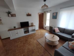 a living room with a couch and a tv at Casa Manito in El Barraco