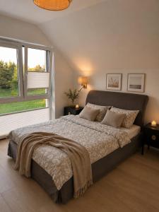 a bedroom with a large bed and two windows at DARESTATE - dom rodzinny in Zgon