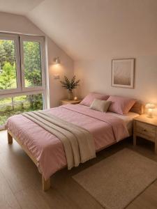 a bedroom with a large bed with pink sheets at DARESTATE - dom rodzinny in Zgon