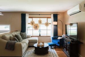 a living room with a couch and a tv at Family Friendly Getaway with Fire Pit & Swing Set in Geneva