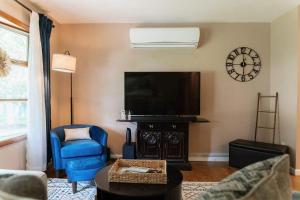a living room with a tv and a blue chair at Family Friendly Getaway with Fire Pit & Swing Set in Geneva