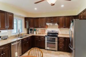 a kitchen with wooden cabinets and stainless steel appliances at Family Friendly Getaway with Fire Pit & Swing Set in Geneva +25 photos