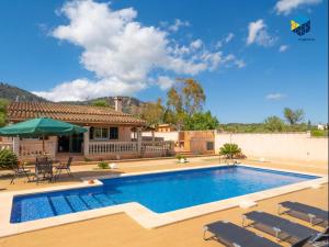 a swimming pool with chairs and a house at Casa Bon Nadal in Llucmajor