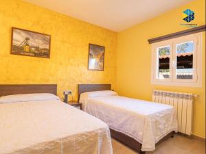 two beds in a room with yellow walls at Casa Bon Nadal in Llucmajor +32 photos